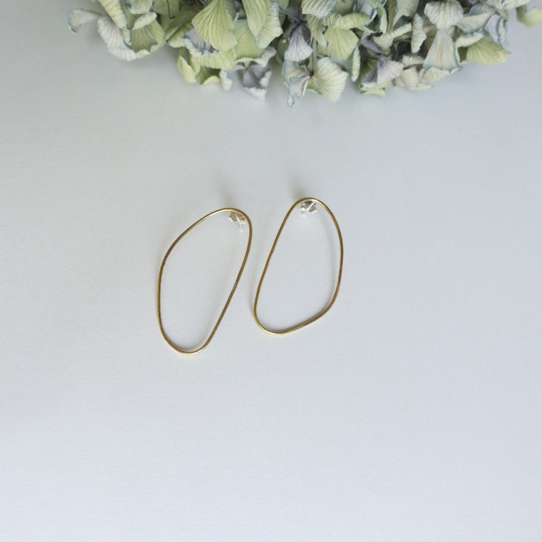 Gold hoop earrings on a light gray background