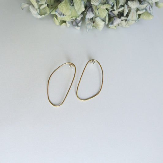 Gold hoop earrings on a light gray background